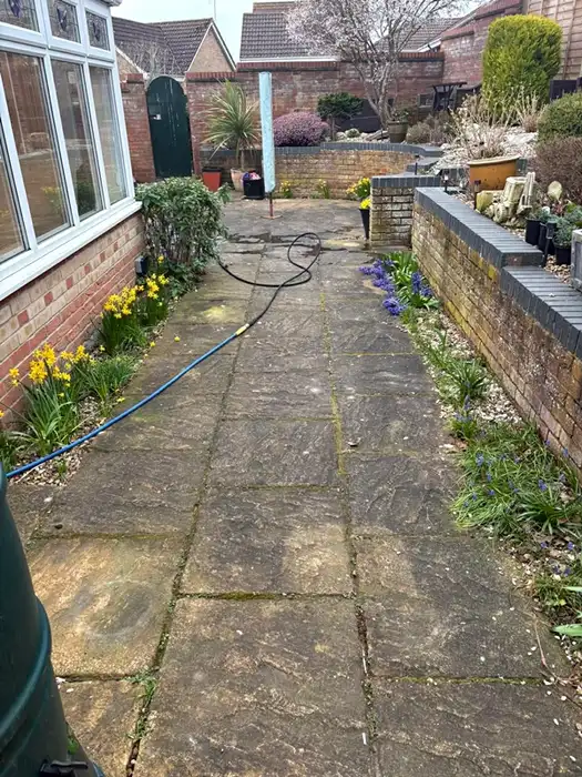Garden patio path covered in green algae and ground-in dirt before cleaning